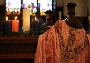Advent wreath with newly lit rose candle beside rose-coloured chasuble