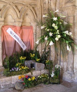 An Easter floral display with a banner reading "Resurrection" and incorporating a cave with the stone rolled away