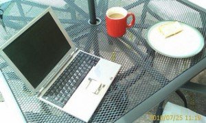 Laptop and working lunch. An outside table with a silver laptop, coffee and a sandwich on it.  © rcp:051010:a0021  This image is released under a Creative Commons Attribution only (free) license. 